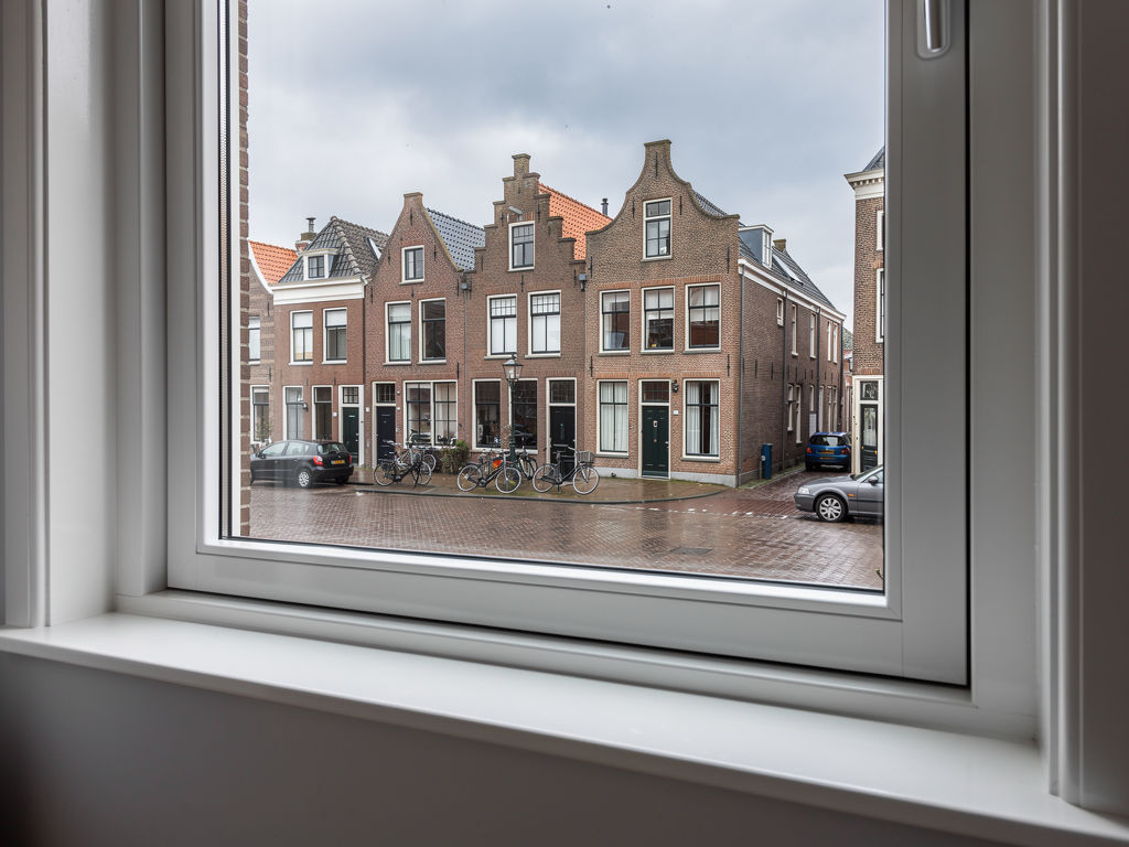 uitzicht door wit kunststof kozijn naar straat in Slootdorp