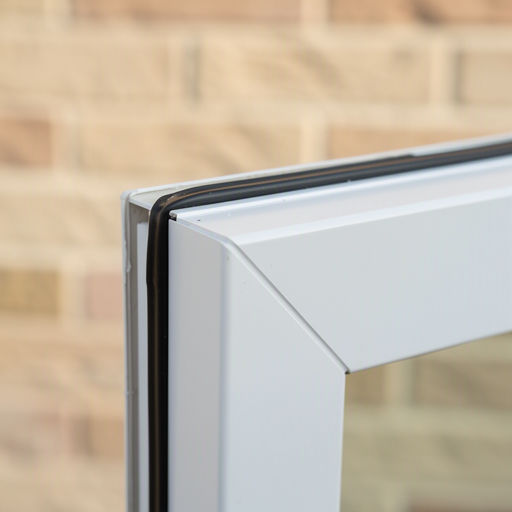 close-up hoekverbinding wit kunststof kozijn met afdichtrubber tegen lichte gevelsteen in Wieringerwerf